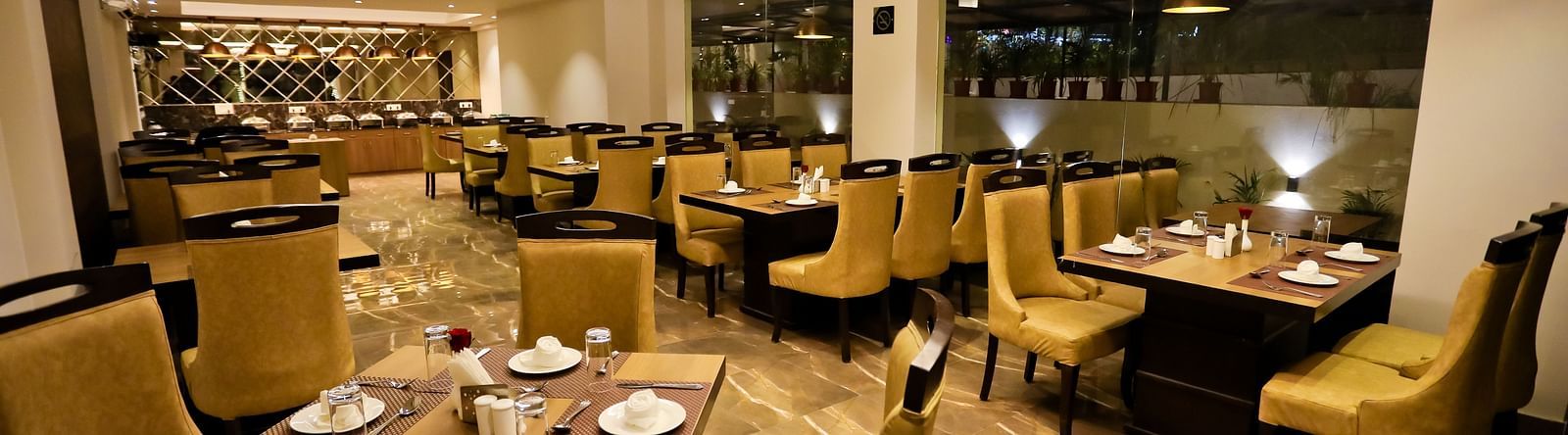 Image of a dining space with crockery placed on the tables and chairs surrounding it at Calux Grand Baga.